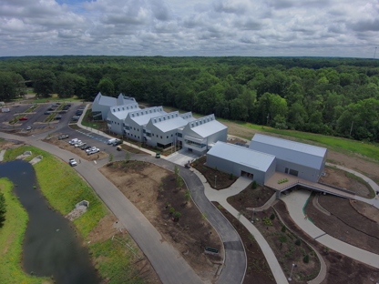 An aerial view of a large facility on a wide, green and open ground.